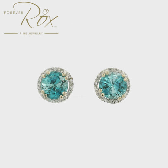 A Pair of White Gold Earrings with prong set round cut natural Blue Zircon in the center with a diamond halo at Forever Rox Fine Jewelry, Lake Tahoes Best Jewelry Store