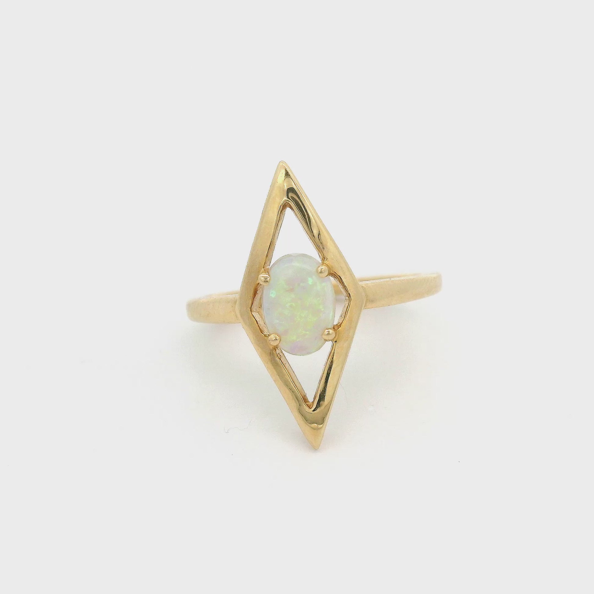 Yellow gold ring with a diamond shape bezel and opal set in middle at Forever Rox Fine Jewelry