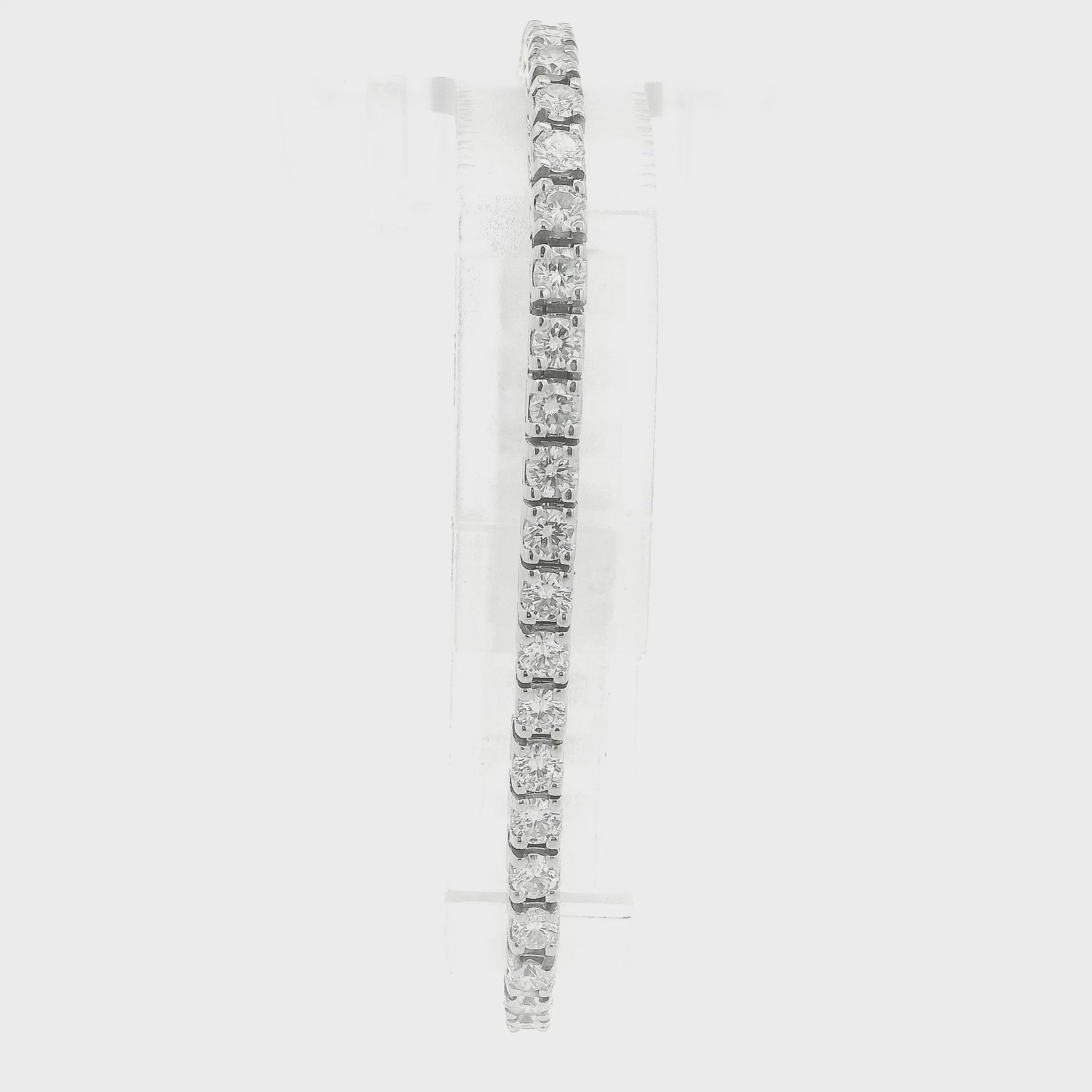A single white gold diamond tennis bracelet displayed vertically on a clear stand against a plain white background at Forever Rox Fine Jewelry, Lake Tahoes Best Jewelry Store