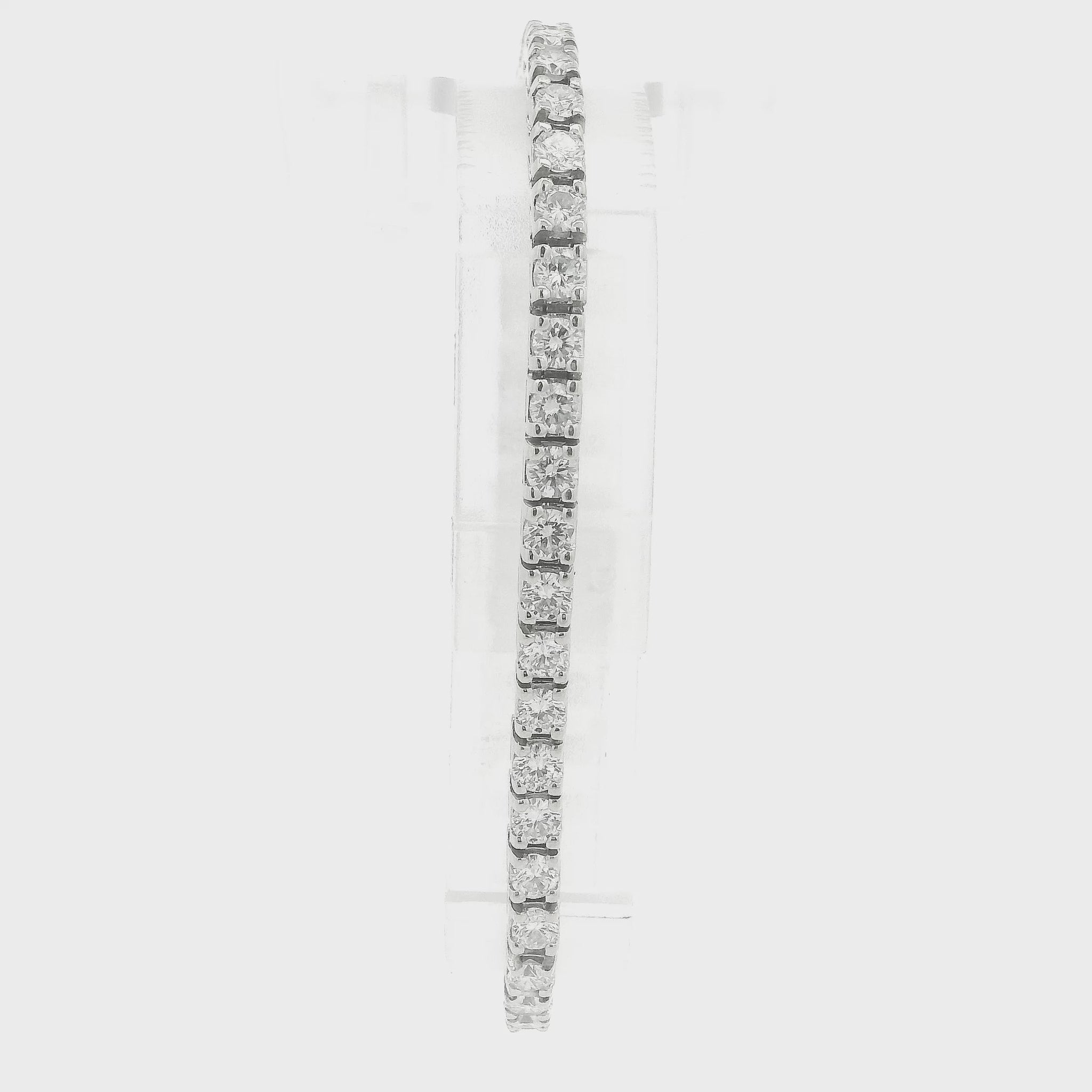A single white gold diamond tennis bracelet displayed vertically on a clear stand against a plain white background at Forever Rox Fine Jewelry, Lake Tahoes Best Jewelry Store