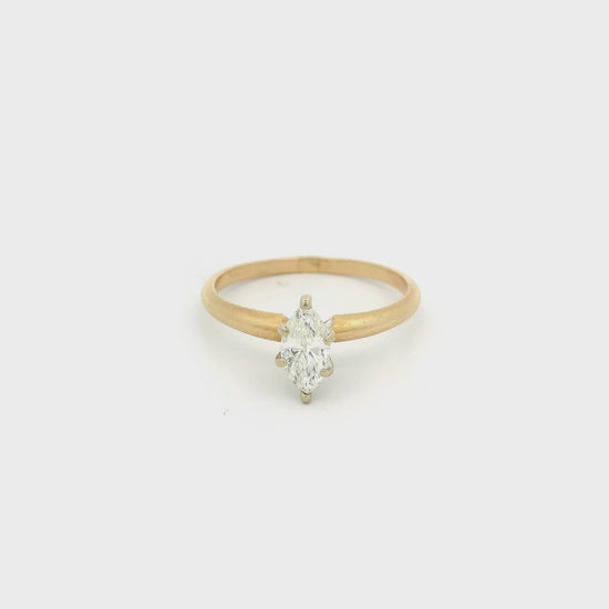 Gold ring with a marquise cut diamond set in white gold in the center at Forever Rox Fine Jewelry