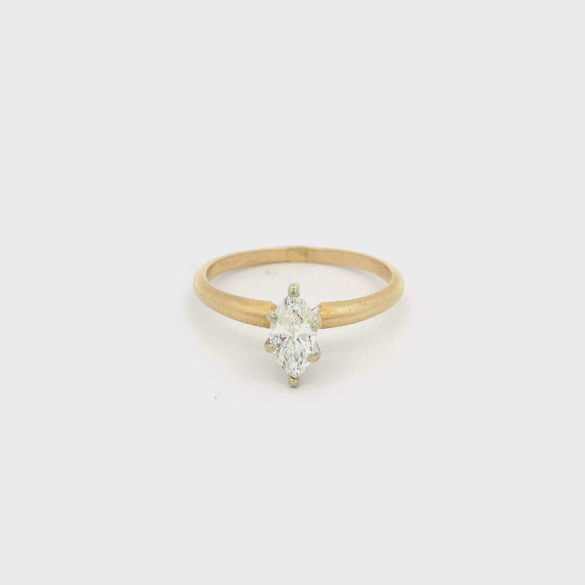 Gold ring with a marquise cut diamond set in white gold in the center at Forever Rox Fine Jewelry