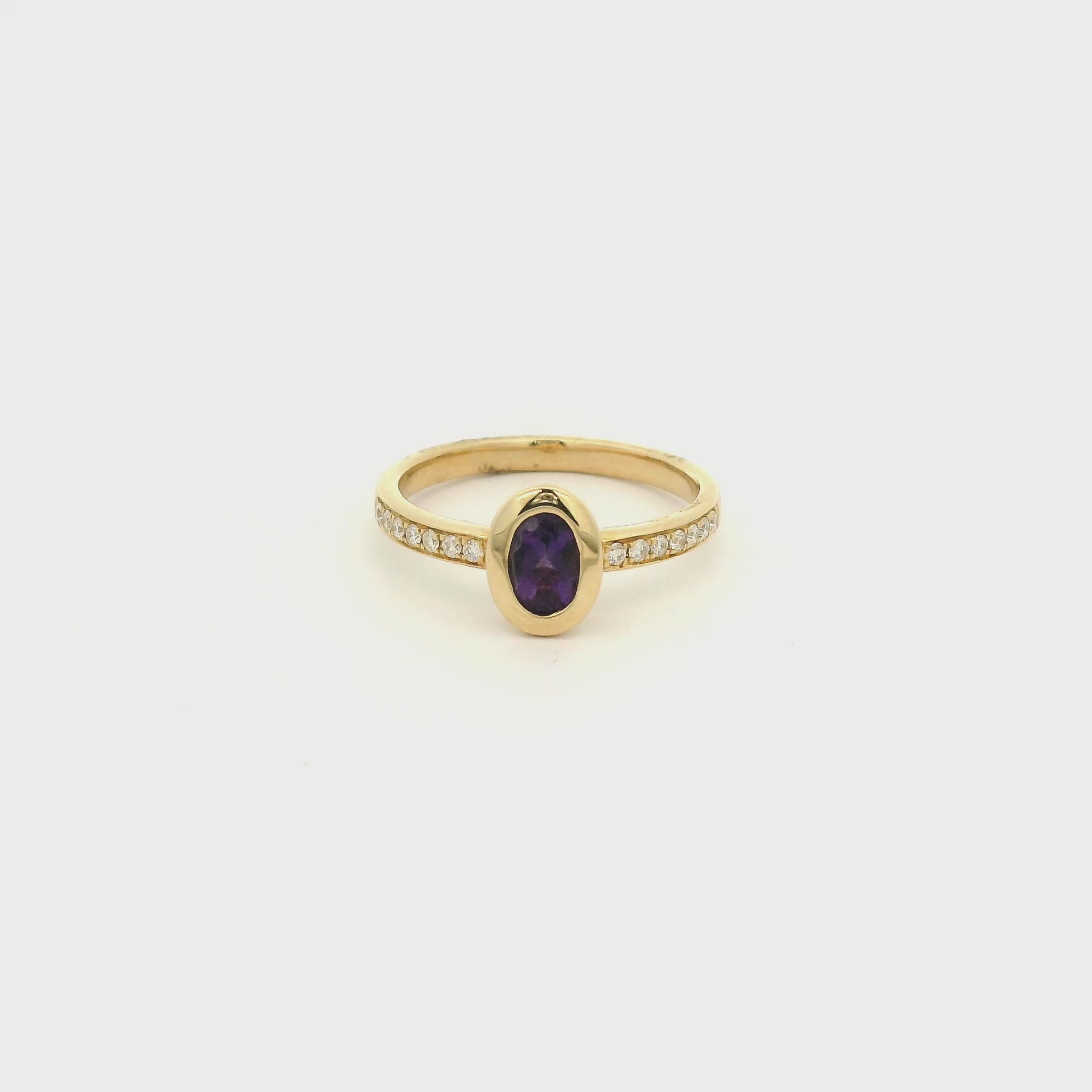 A Yellow Gold Ring with a bezel set oval cut natural Amethyst in the center with diamonds down the shank at Forever Rox Fine Jewelry, Lake Tahoes Best Jewelry Store