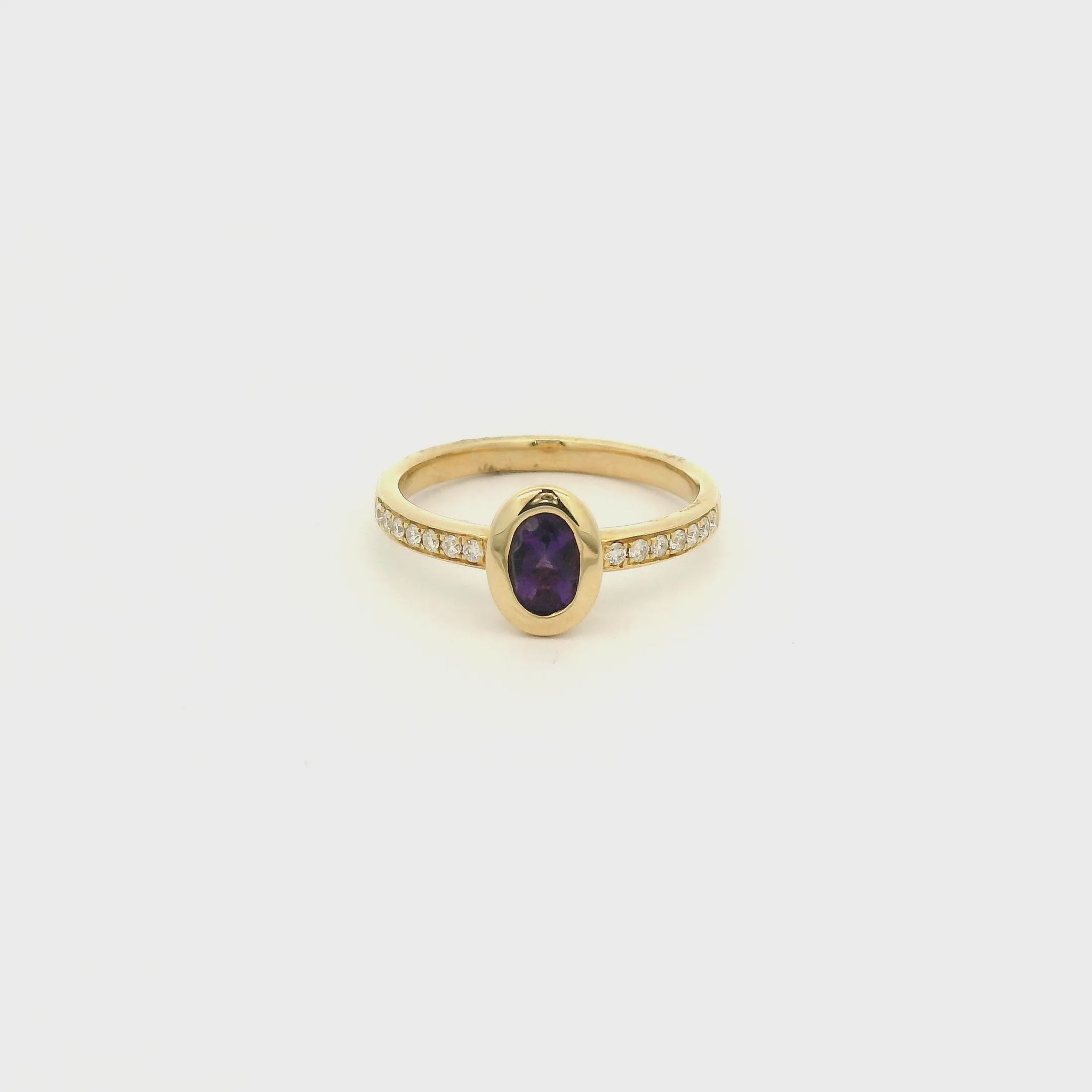 A Yellow Gold Ring with a bezel set oval cut natural Amethyst in the center with diamonds down the shank at Forever Rox Fine Jewelry, Lake Tahoes Best Jewelry Store