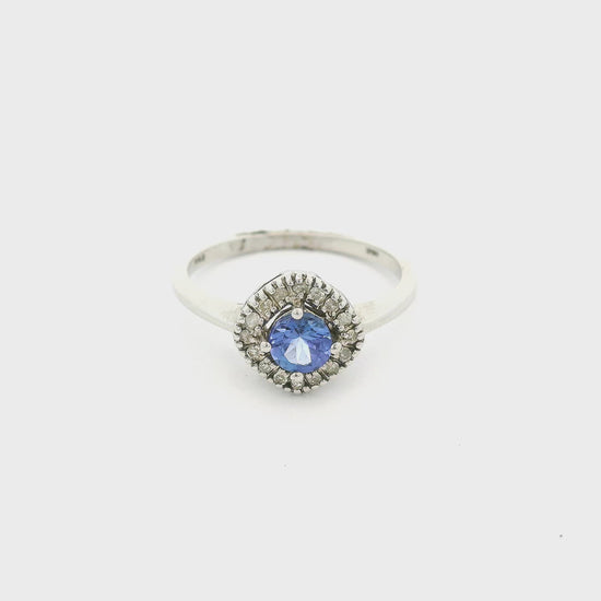 A White Gold Ring with a prong set round cut natural Tanzanite in the center with a halo of diamonds around it at Forever Rox Fine Jewelry, Lake Tahoes Best Jewelry Store