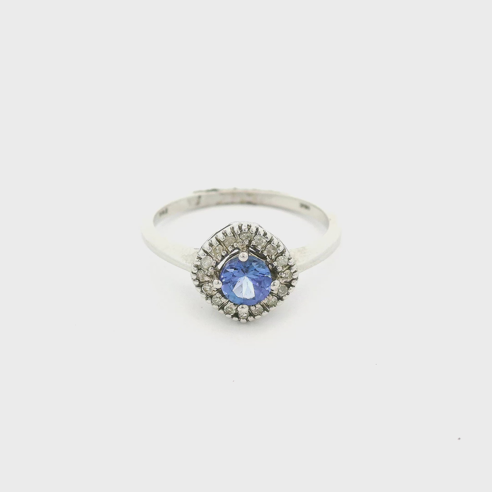 A White Gold Ring with a prong set round cut natural Tanzanite in the center with a halo of diamonds around it at Forever Rox Fine Jewelry, Lake Tahoes Best Jewelry Store
