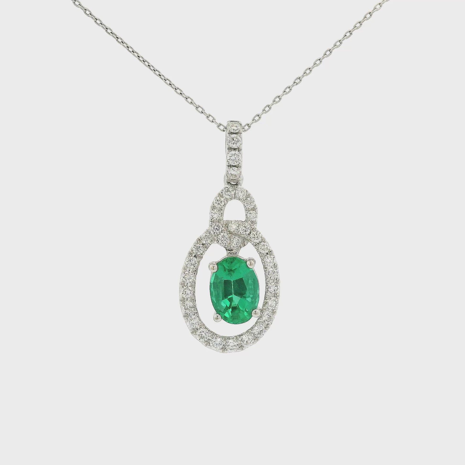 A White Gold Pendant with a prong set oval cut Emerald in the center with a interlinked design pendant with diamonds at Forever Rox Fine Jewelry, Lake Tahoes Best Jewelry Store