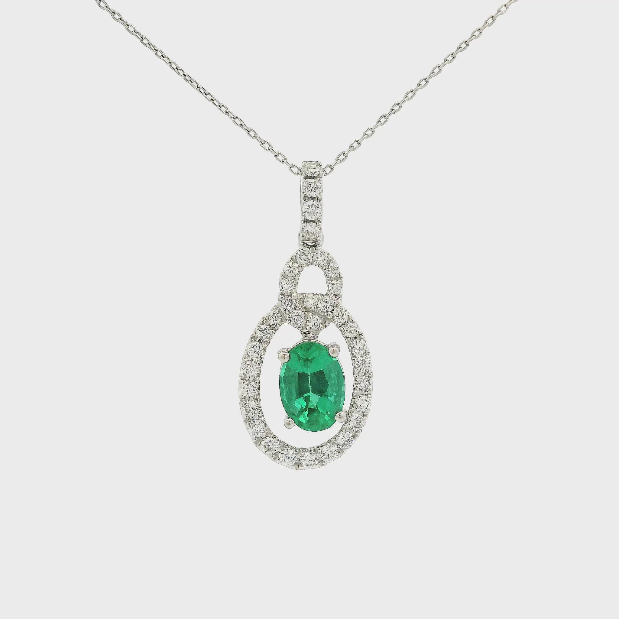A White Gold Pendant with a prong set oval cut Emerald in the center with a interlinked design pendant with diamonds at Forever Rox Fine Jewelry, Lake Tahoes Best Jewelry Store