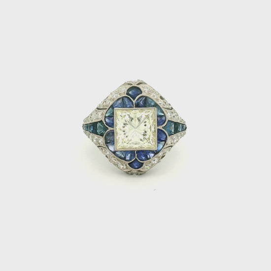 A Platinum Ring with a bezel set princess cut natural Diamond in the center with Sapphire and diamonds all around the ring at Forever Rox Fine Jewelry, Lake Tahoes Best Jewelry Store