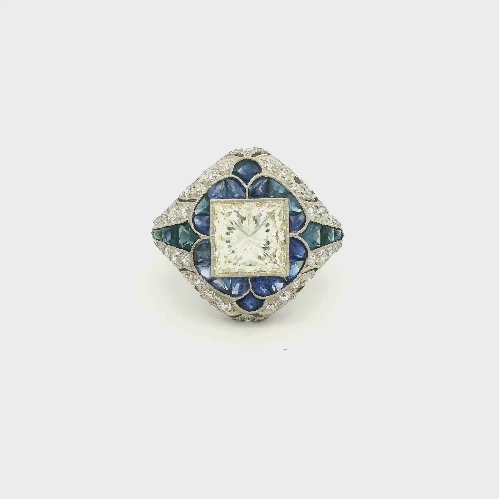 A Platinum Ring with a bezel set princess cut natural Diamond in the center with Sapphire and diamonds all around the ring at Forever Rox Fine Jewelry, Lake Tahoes Best Jewelry Store