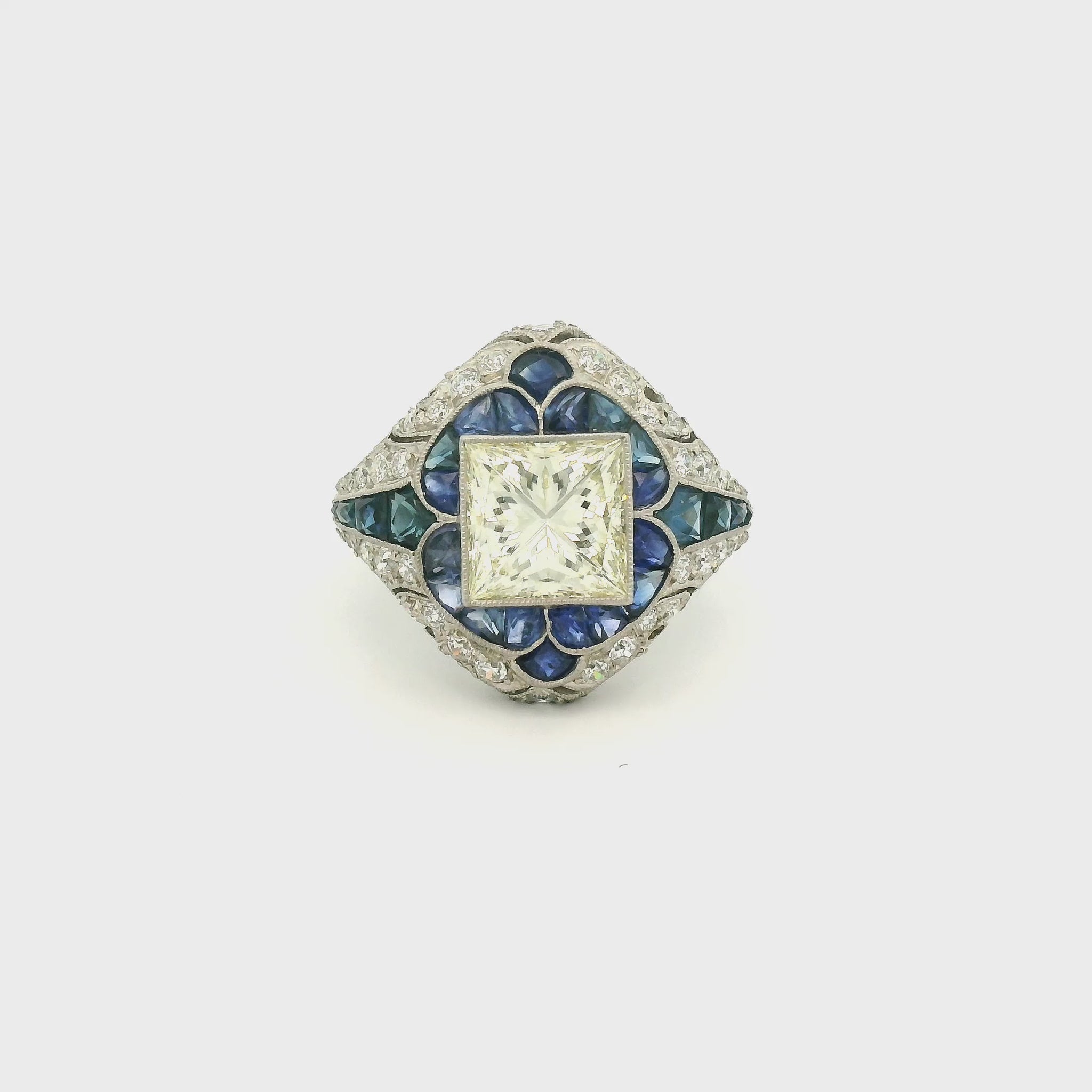 A Platinum Ring with a bezel set princess cut natural Diamond in the center with Sapphire and diamonds all around the ring at Forever Rox Fine Jewelry, Lake Tahoes Best Jewelry Store