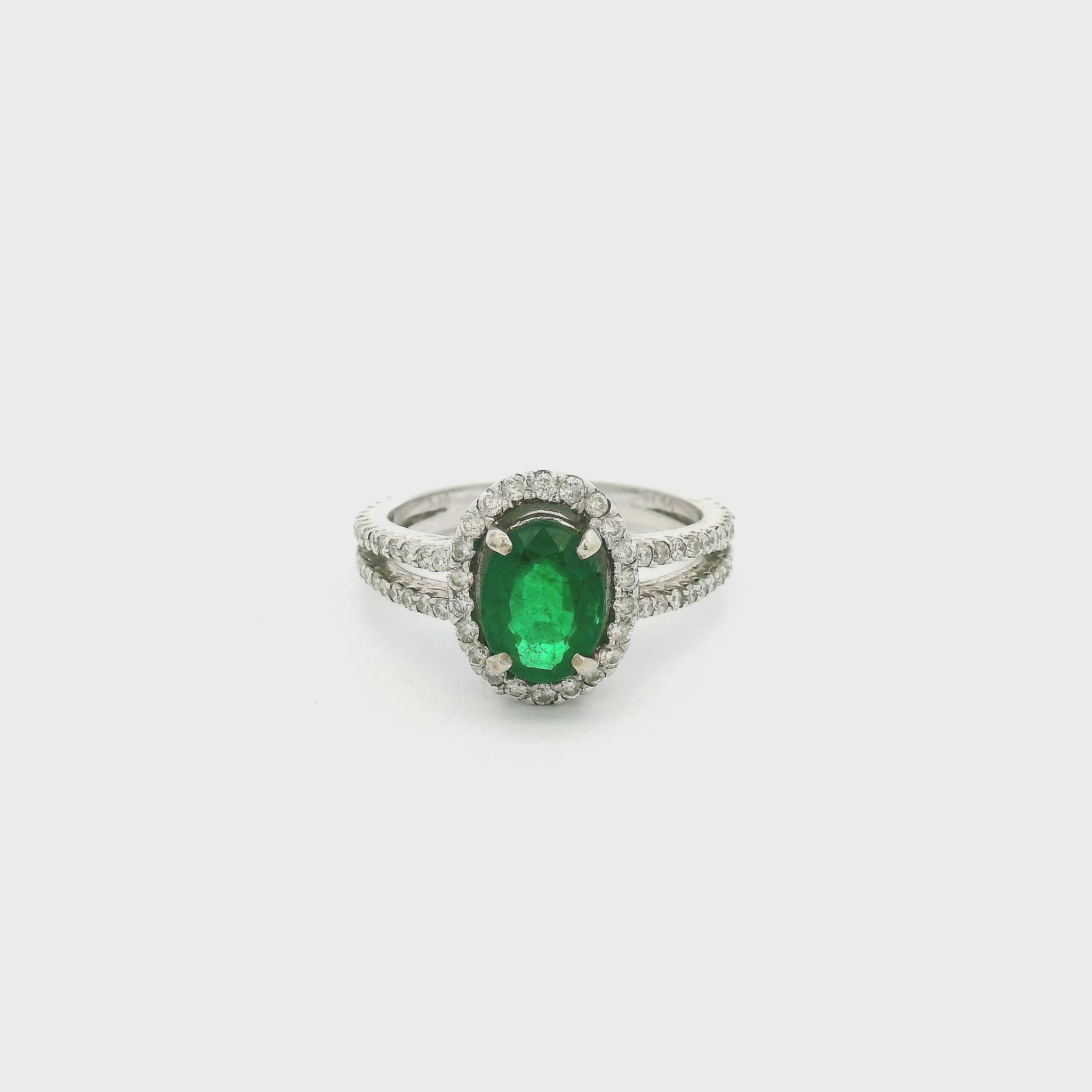 A White Gold Ring with a prong set oval cut natural Emerald in the center with a diamond halo & diamonds down the split shank at Forever Rox Fine Jewelry, Lake Tahoes Best Jewelry Store